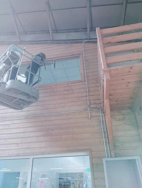 Nettoyage de vitres en hauteur avec raclette